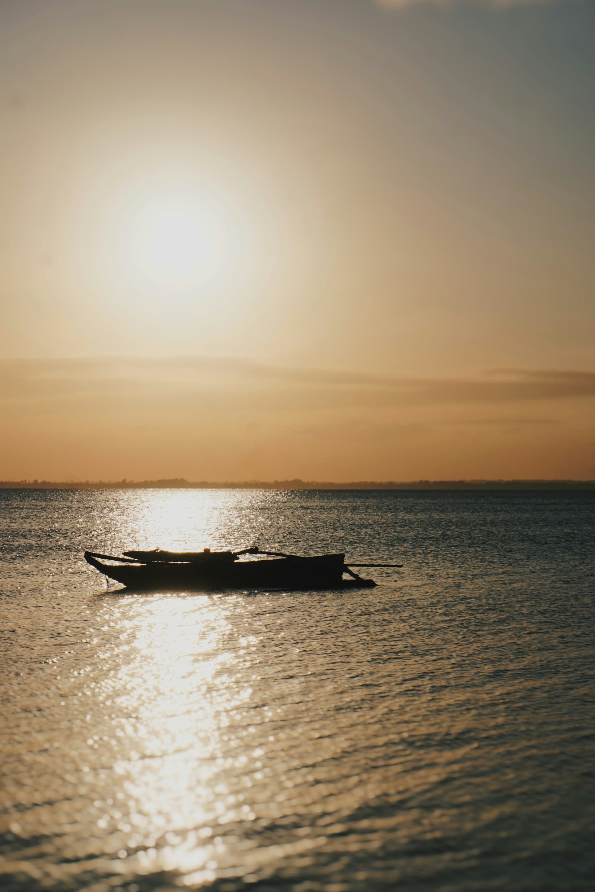 A wooden boat silhouetted on the Indian Ocean at sunset