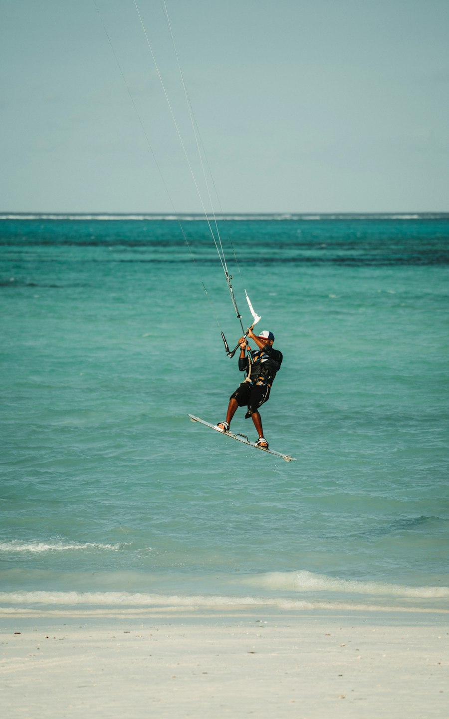 A kitesurfer skimming over the shallow turquoise lagoon