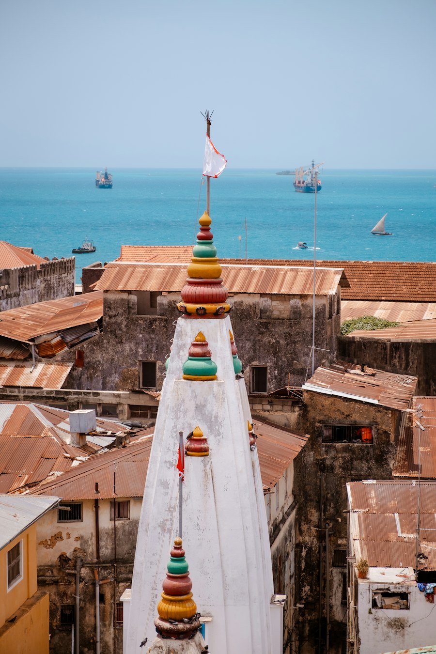 Stone Town rooftops with dhows sailing on the harbour beyond