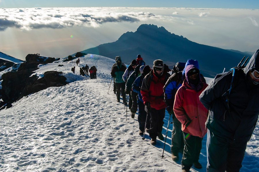Climbers in warm layers on a snowy summit ridge